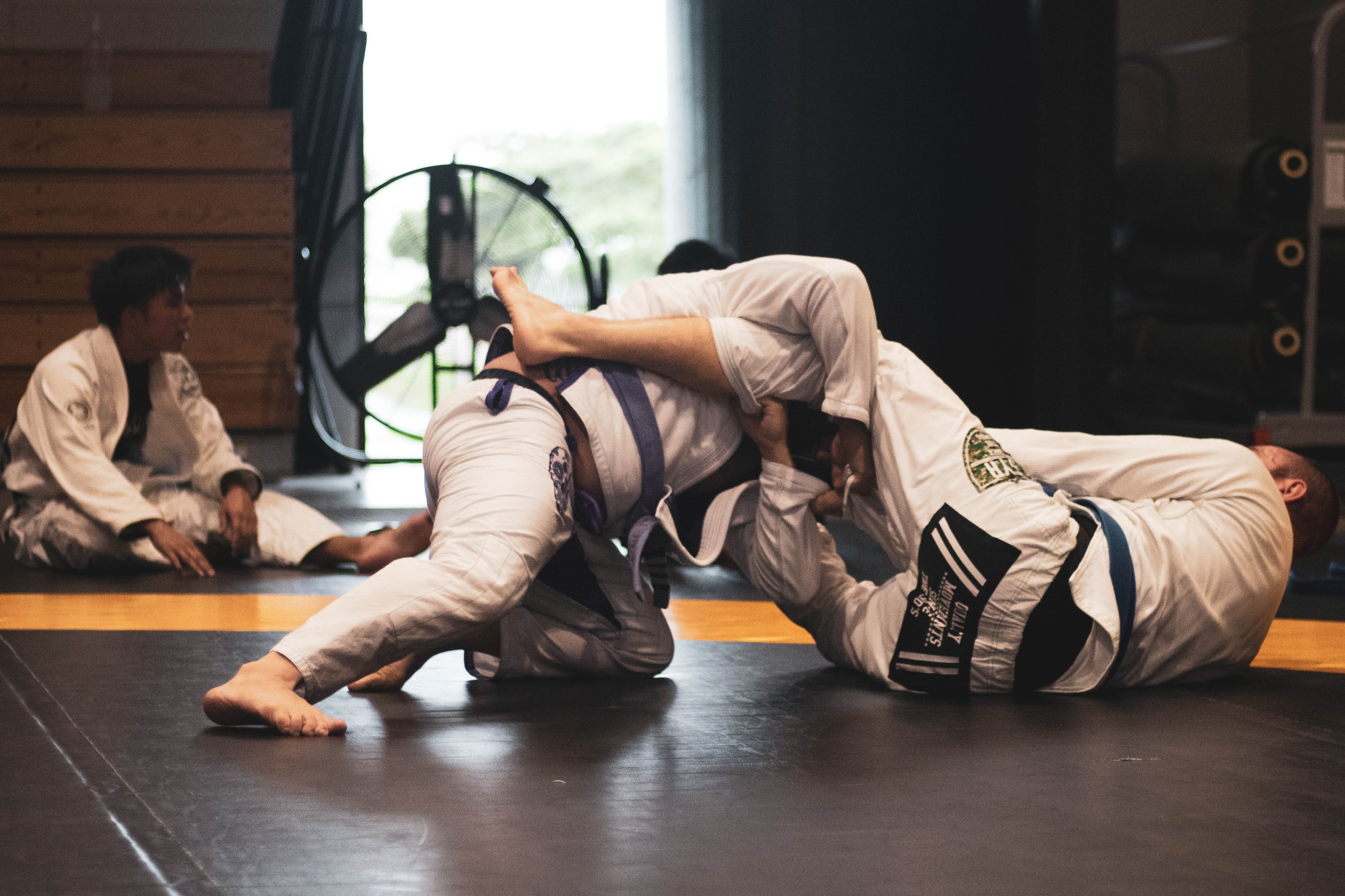 Two men grappling on mat MMA