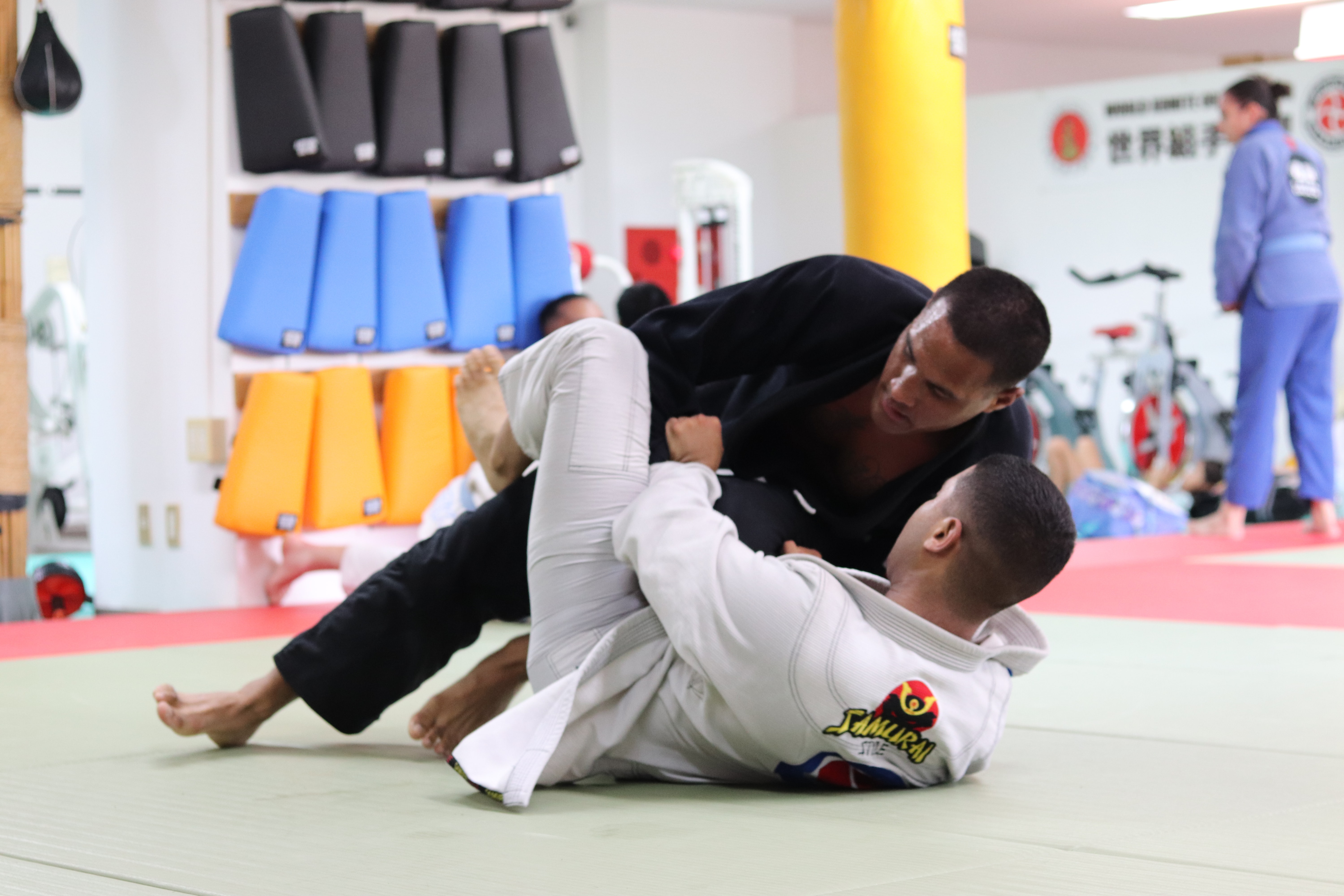 Two men grappling on mat MMA